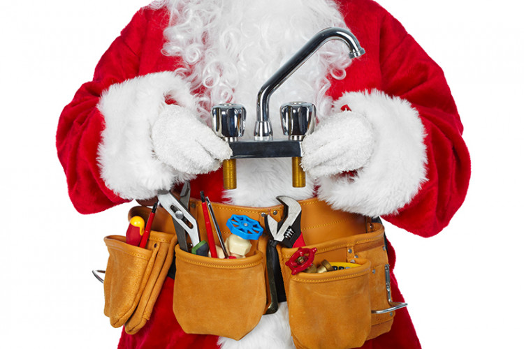 Santa wearing a tool belt and holding a faucet.