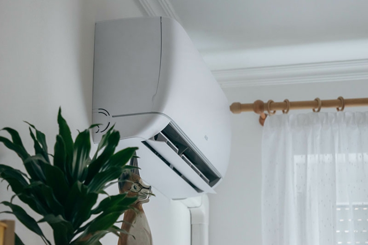 Ductless heat system unit on a white interior wall.