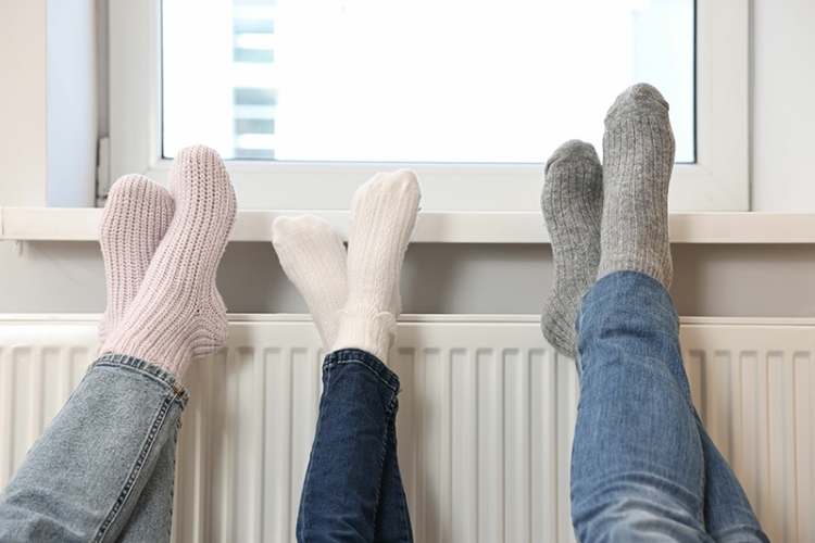 family warming feet near heat radiator.