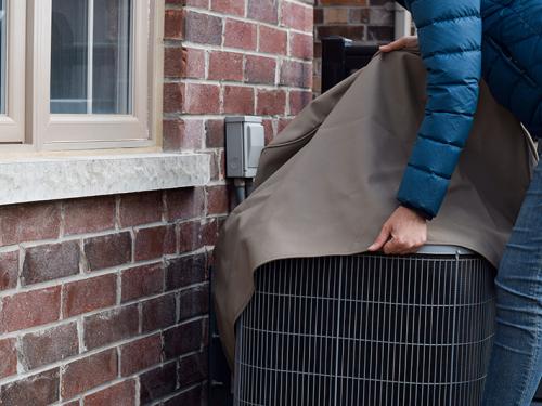 Woman putting cover on AC unit