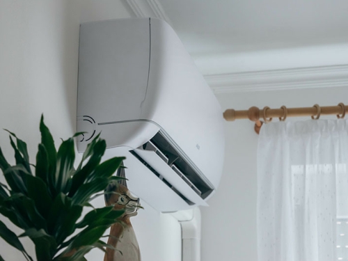Ductless heat system unit on a white interior wall.