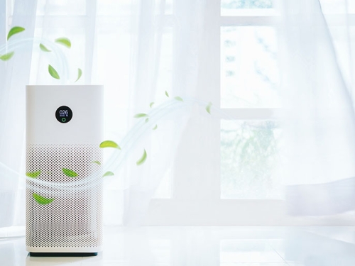 Air purifier beside an open window with fresh air currents streaming out of it.