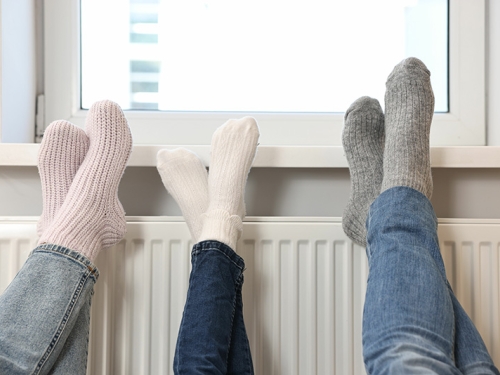 family warming feet near heat radiator.