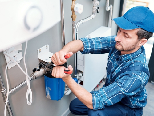 Technician installing water filtration system.