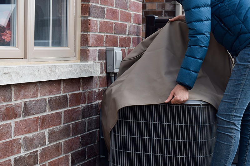 Woman putting cover on AC unit