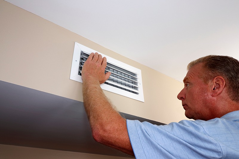 Man inspecting air vent
