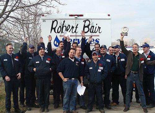 Robert Bair Staff Holds Award Up